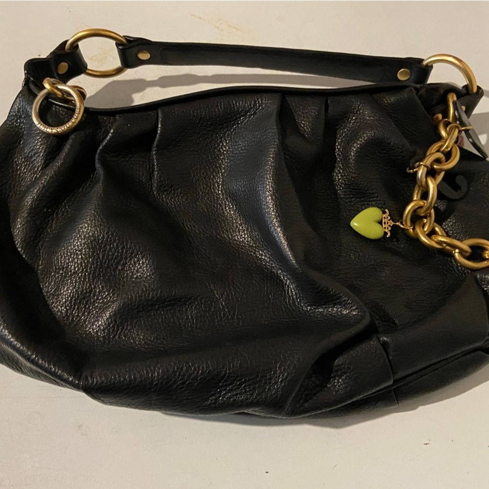 Juicy Black Leather Hand bag. Purse sits below the armpit but above hip.